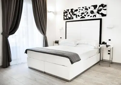 a white bedroom with a large white bed and a window at LHP Suite Roma Termini in Rome