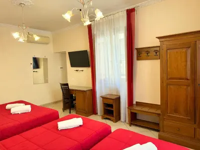 a bedroom with two red beds and a desk at Anthony House, Anthony Floor 3, Castro Pretorio in Rome