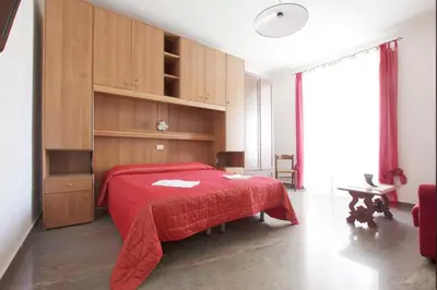 a bedroom with a red bed and wooden cabinets at Domi 56 Apartment in Rome