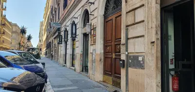 a narrow street with cars parked on the side at Domi 56 Apartment in Rome