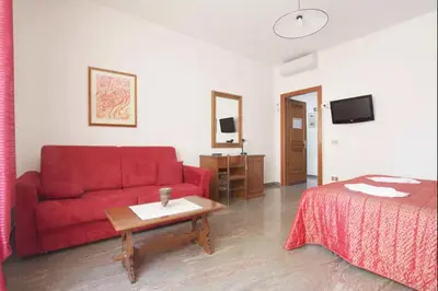 a living room with a red couch and a bed at Domi 56 Apartment in Rome