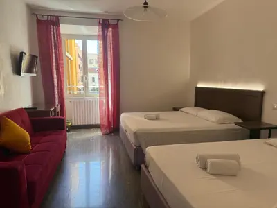 a hotel room with two beds and a couch at Domi 56 Apartment in Rome