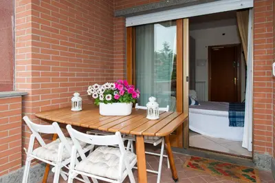 a wooden table with chairs and flowers on a patio at Residenza il Parco 3 in Rome