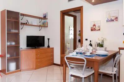 a dining room with a table with chairs and a television at Residenza il Parco 3 in Rome