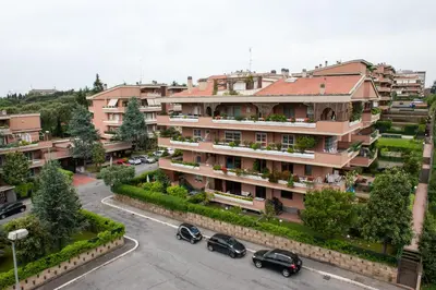 an apartment building with cars parked in a parking lot at Residenza il Parco 3 in Rome
