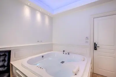 a large white bath tub in a white room at Hotel dei Quiriti Suite in Rome