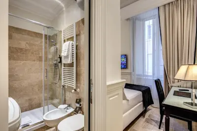 a bathroom with a toilet and a shower and a sink at Hotel dei Quiriti Suite in Rome