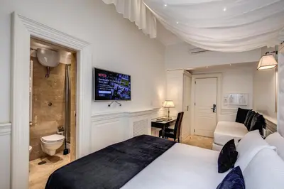 a hotel room with a bed and a bathroom at Hotel dei Quiriti Suite in Rome