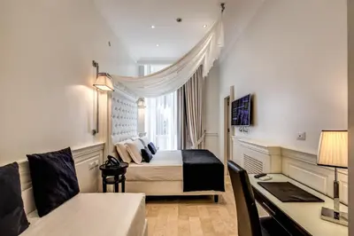 a hotel room with a bed and a desk at Hotel dei Quiriti Suite in Rome