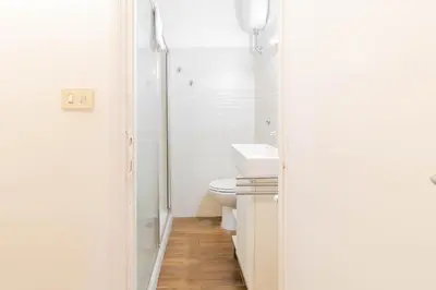 a white bathroom with a toilet and a sink at Tevere apartments in Rome