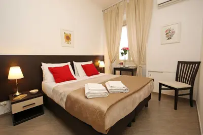 a bedroom with a large bed with red pillows at Great Central Apartment in Rome