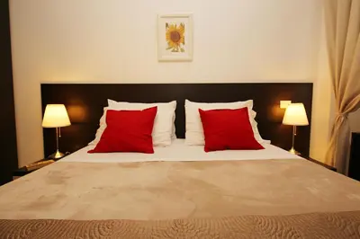 a bedroom with a bed with red pillows and two lamps at Great Central Apartment in Rome