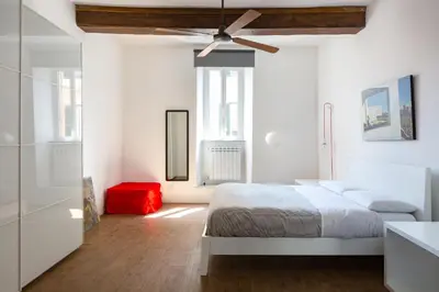 a white bedroom with a bed and a ceiling fan at Vicoloft Vicolo in Rome