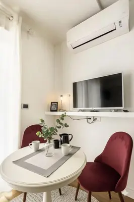 a dining room with a white table and two red chairs at Terrace with Tiber View - Trastevere in Rome