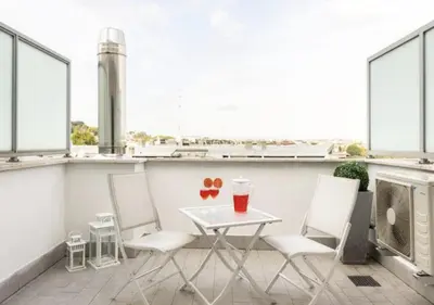 a table and chairs on a balcony with windows at Terrace with Tiber View - Trastevere in Rome