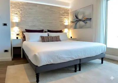 a bedroom with a large white bed with a brick wall at Terrace with Tiber View - Trastevere in Rome