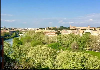 a view of a city with a river and buildings at Terrace with Tiber View - Trastevere in Rome