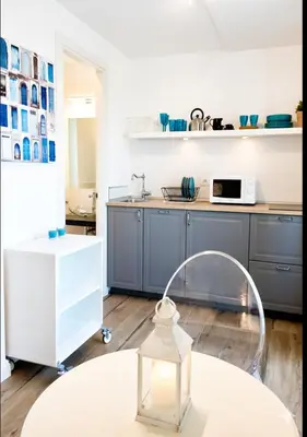 a kitchen with blue cabinets and a white counter top at Terrace with Tiber View - Trastevere in Rome