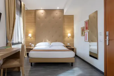 a hotel room with a bed and a desk at Phi Hotel Garden Area Roma Eur in Rome