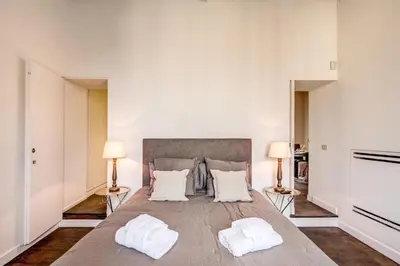 a large bedroom with a large bed with two lamps at Piazza Farnese exclusive view 2 bedroom en suite in Rome