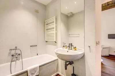 a bathroom with a sink and a bath tub at Piazza Farnese exclusive view 2 bedroom en suite in Rome