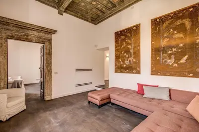 a living room with a couch and a painting on the wall at Piazza Farnese exclusive view 2 bedroom en suite in Rome