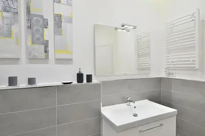 a white bathroom with a sink and a mirror at New Romantic Trastevere Apartment in Rome