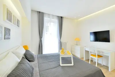 a bedroom with a bed and a desk and a television at New Romantic Trastevere Apartment in Rome