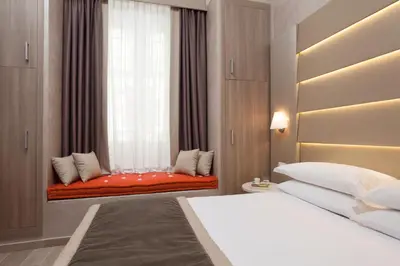 a bedroom with a bed and a window with a red couch at Jackie's Apartments in Rome
