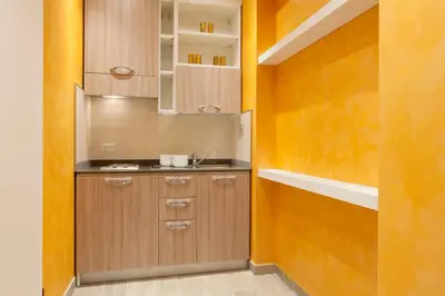 a kitchen with wooden cabinets and a sink at Jackie's Apartments in Rome