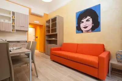 a living room with a orange couch and a painting at Jackie's Apartments in Rome