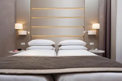 a bedroom with two beds and two tables and two lamps at Jackie's Apartments in Rome