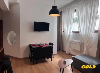 a living room with a table and a tv on the wall at Albornoz 35 in Rome