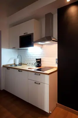 a kitchen with white cabinets and a stove top oven at Albornoz 35 in Rome