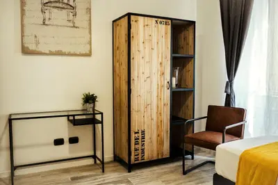 a room with a bed and a wooden door at BMGA l Stylish Industrial Termini Apartment in Rome