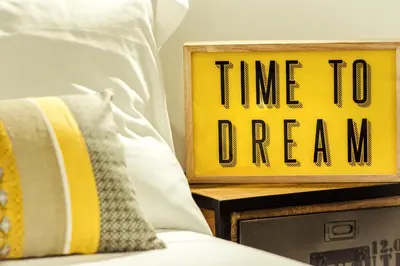 a sign that says time to dream next to a bed at BMGA l Stylish Industrial Termini Apartment in Rome