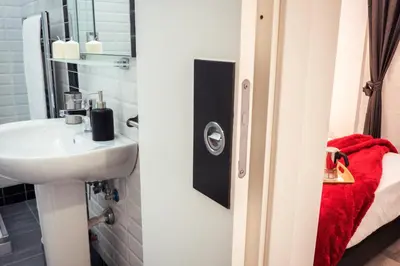 a bathroom with a sink and a mirror at BMGA l Stylish Industrial Termini Apartment in Rome