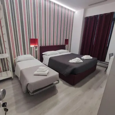 two beds in a hotel room with towels on them at Sangiò Guest House in Rome
