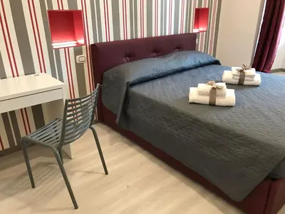 a bedroom with a bed and a desk and a chair at Sangiò Guest House in Rome