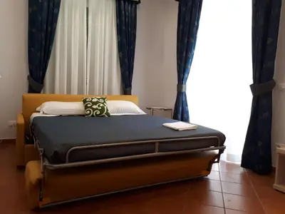 a bedroom with a bed with blue curtains at Clodio Rooms in Rome