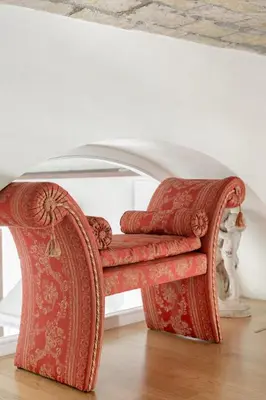 a red chair sitting on a wooden floor in a room at Leopardo 28 - Loft in Trastevere in Rome