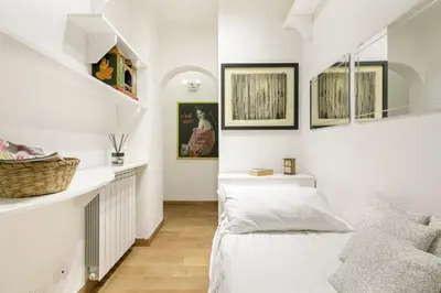 a living room with white walls and a stair case at Leopardo 28 - Loft in Trastevere in Rome