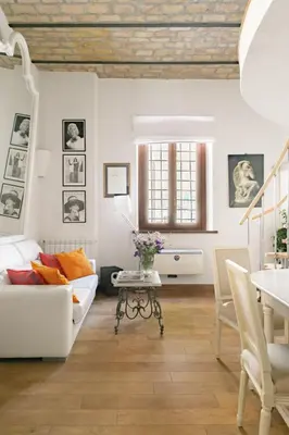 a living room with a white couch and a table at Leopardo 28 - Loft in Trastevere in Rome