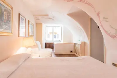 a bedroom with a red window curtain and a red chair at Piazza Colonna Apartment - Charme Holidays in Rome