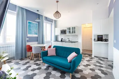 a living room with a blue couch and a kitchen at Lata Luxury Penthouse in Rome
