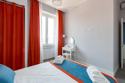 a bedroom with a bed and a window with red curtains at Lata Luxury Penthouse in Rome