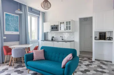 a living room with a blue couch and a kitchen at Lata Luxury Penthouse in Rome