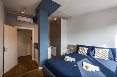 a bedroom with a blue bed with towels on it at Expeditus VATICAN Luxury Suites SAINT PETER'S VIEW in Rome