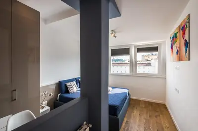 a small room with a blue couch and a window at Expeditus VATICAN Luxury Suites SAINT PETER'S VIEW in Rome