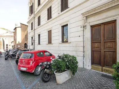 a red car is parked next to a building at Al Portico 39 Apartment in Rome